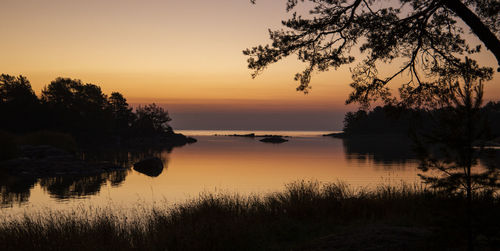 Scenic view of lake against orange sky