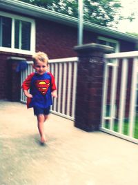 Full length of boy standing on railing