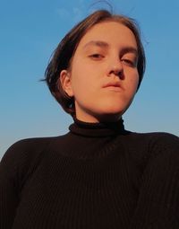 Portrait of teenage boy against blue sky