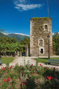 Square, stone building and flowery garden in conflans, france.