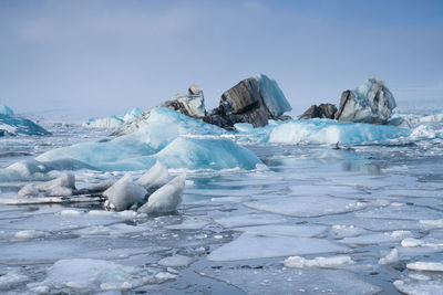 Icebergs in sea against sky during winter