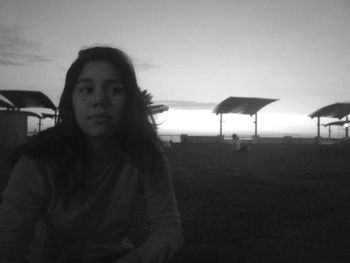 Portrait of young woman on beach against sky