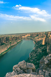 Scenic view of river against cloudy sky