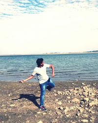 Full length of man standing on beach against sky
