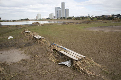 Lifeguard hut on field by buildings against sky