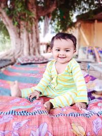 Portrait of smiling girl sitting on bed