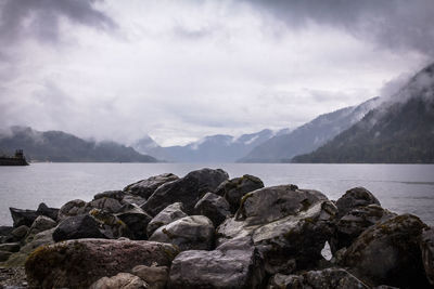 Scenic view of sea and mountains against sky