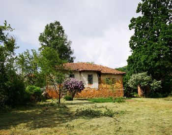 House on field by building against sky