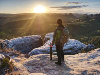 Rear view of man looking at mountains against sky