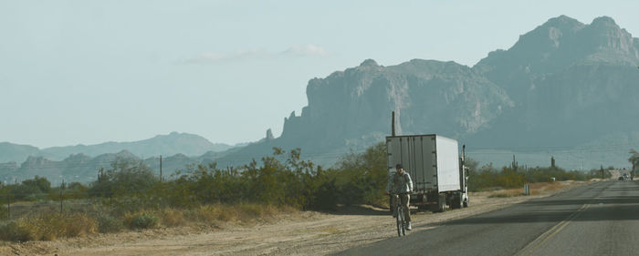 Panoramic image of man riding bicycle on road 