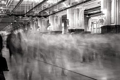 Blurred motion of people walking on illuminated railroad station