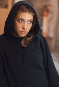 Portrait of beautiful woman standing against curtain