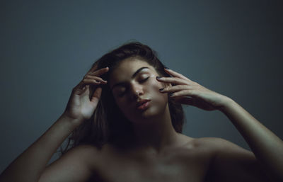 Portrait of young woman against gray background