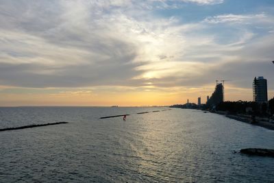 Scenic view of sea against cloudy sky during sunset