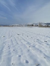 Scenic view of snow covered field against sky