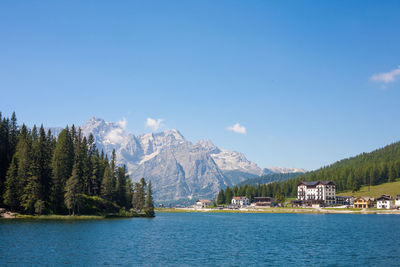 Scenic view of lake and mountains against blue sky