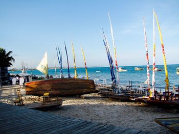 Sailboats moored on sea against sky