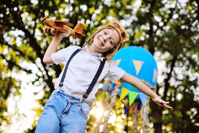 Low angle view of boy playing with toy airplane