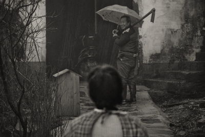 Rear view of people walking on road amidst trees