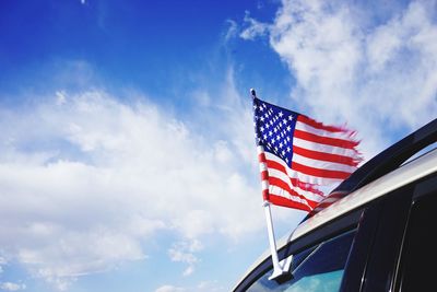 Low angle view of american flag against cloudy sky