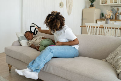 Young woman sitting on sofa at home