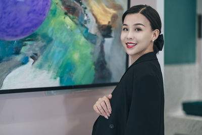 Portrait of smiling young woman standing outdoors