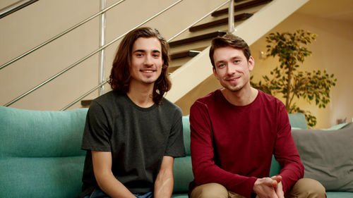 Portrait homosexual couple sitting at home