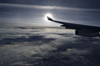 Cropped image of airplane flying over cloudscape