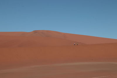 Scenic view of desert against clear blue sky