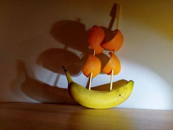 Close-up of apples on table against orange wall