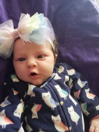 Close-up portrait of cute baby lying on bed