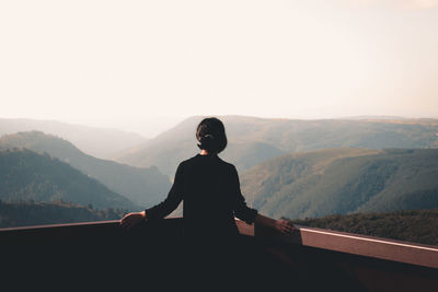 Rear view of man standing against mountain