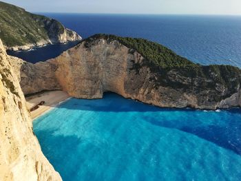 Rock formation against sea in sunny day