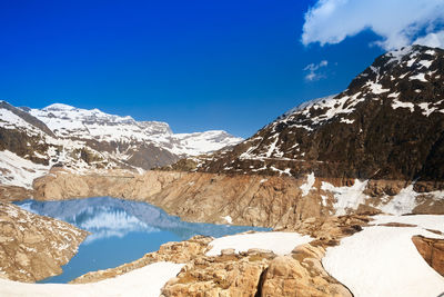 Scenic view of snowcapped mountains against blue sky