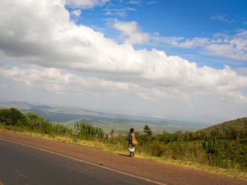 Man riding bicycle on road against sky