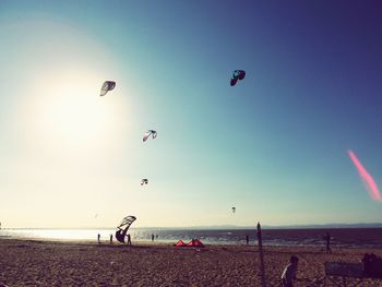 Parachutes in clear sky over beach