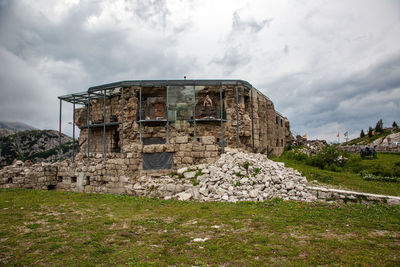 Old ruin building on field against sky