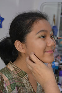 Close-up portrait of a smiling young woman looking away