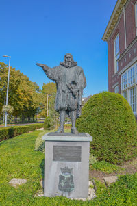 Statue in cemetery against clear sky