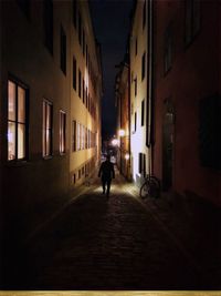 Man walking on illuminated street at night
