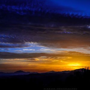 Silhouette of mountain range against dramatic sky