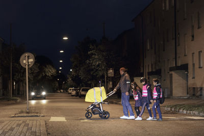 Father with children crossing road at evening