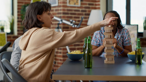 Businesswoman playing jenga with colleagues