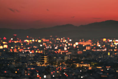 High angle view of illuminated city against sky at sunset