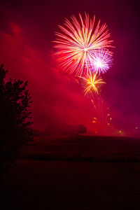 Low angle view of firework display at sunset