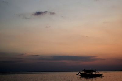 Silhouette boat sailing on sea against sky during sunset