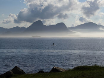 Scenic view of sea and mountains against sky