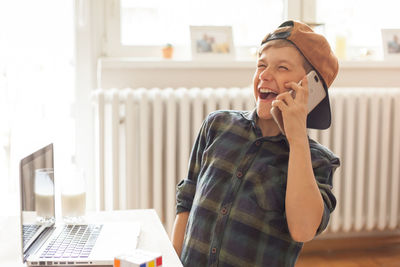 Mid adult man using smart phone at home