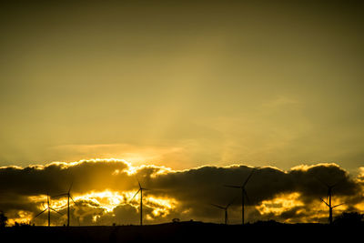 Silhouette of wind turbines at sunset