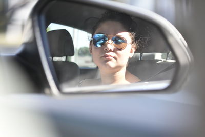 Portrait of woman wearing sunglasses in car